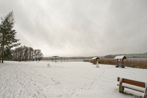 Zaśnieżona plaża nad jeziorem Pile z bałwanami